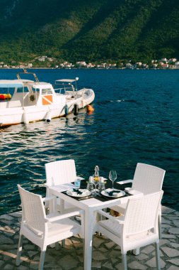 Sandalyeli şenlik masası deniz kıyısındaki iskelede duruyordu.
