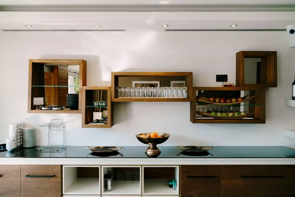 Kitchen with wooden shelves, table and fruit bowl — Fotografia de Stock