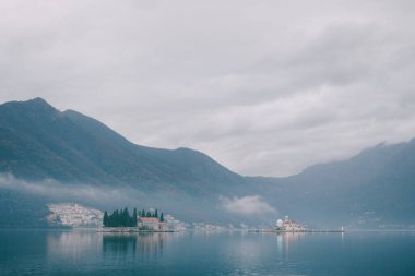 Perast sahilinde sis ve Kotor Körfezi 'nde küçük adalar.