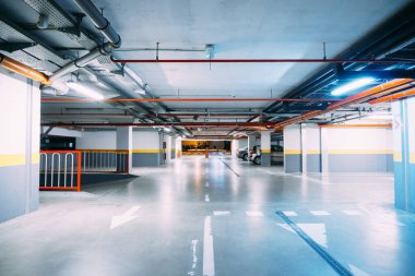 Büyük, ısıtmalı bir yeraltı otoparkında ışıklandırmalı koridorlar.
