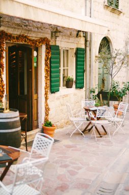 Kırsal bir kafenin duvarlarının yanındaki ahşap masalar.