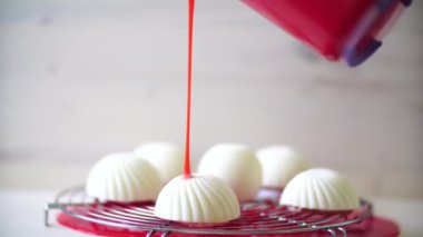 Pasta şefi kırmızı aynalı beyaz kremalı kek doldurur.