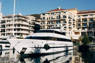 Arka planda otel olan çift güverte yatı rıhtıma demirlemiş.