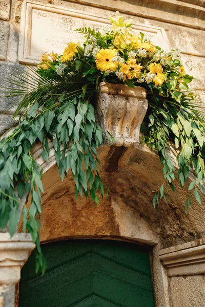 Flower-adorned entrance to the old stone church — Fotografia de Stock
