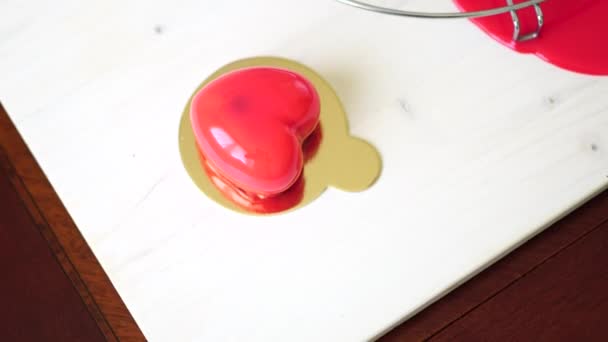 Hjärtformad tårta ligger på ett bord på en guldbas — Stockvideo
