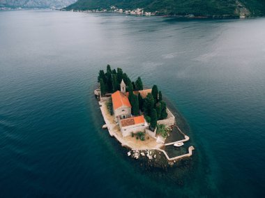 Arkasında dağlar olan Kotor Körfezi 'ndeki Aziz George Adası.