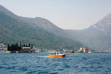 Kotor Körfezi 'ndeki Aziz George adasından bir tekne geçiyor.