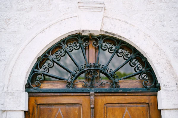 Monogrammed metal wrought iron lattice over wooden door — Fotografia de Stock