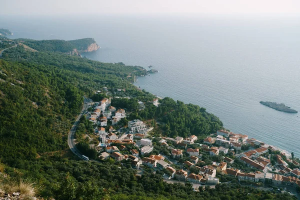Aerial view of red tiled roofs of houses of a seaside town at the foot of the mountains — Stock Fotó