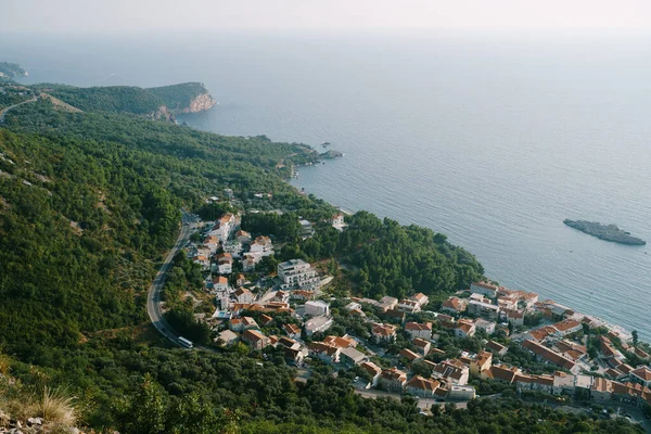 Aerial view of red tiled roofs of houses of a seaside town at the foot of the mountains — стоковое фото