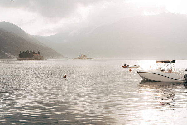 Yachts and boats are moored overlooking the small islands in the Bay of Kotor