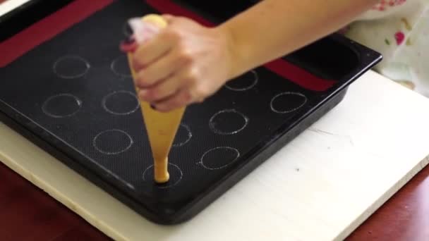 Pasticcere spreme choux au craquelin da un sacchetto di pasticceria su una teglia — Video Stock