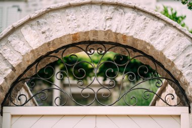 Kemerli metal, taş bir çitte dövülmüş kafes. Yakın plan.