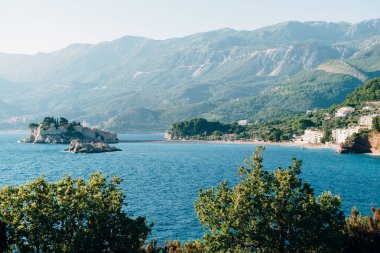 Kotor Körfezi 'ndeki Sveti Stefan Adası' nın arka planında dağlar ve kıyılar var.