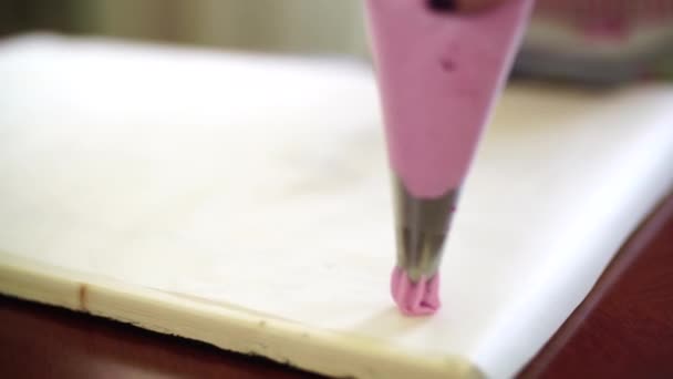 Pastry chef squeezes fruit marshmallows from a baking sack onto baking paper — Stockvideo