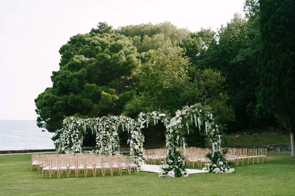 Fila de arcos de boda está rodeado de sillas en un césped verde — Foto de Stock