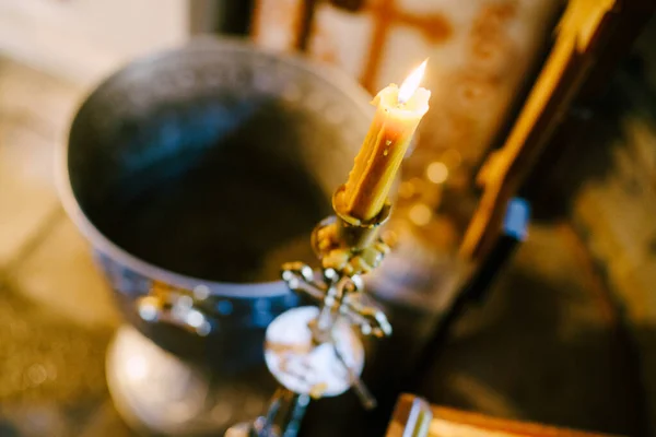 Vosková svíčka na svícnu u velké mísy v chrámu — Stock fotografie