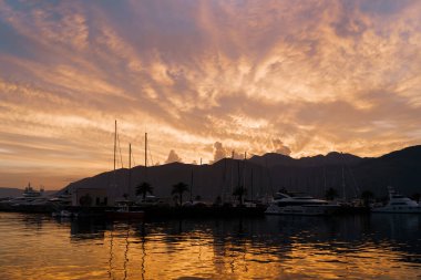 İskeledeki dağların üzerinde yatlarla gün batımı. Porto