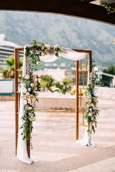 Dikdörtgen ahşap kemer denizin setinde duruyor.