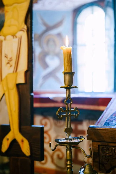 Vosková svíčka na svícnu u krucifixu v chrámu — Stock fotografie