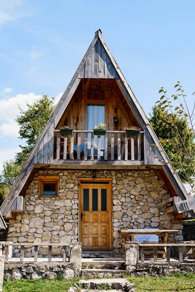 Two-storey triangular house with a terrace, a table and a bench at the entrance. Montenegro — Stockfoto