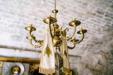 Simple chandelier on a chain in a church under a stone ceiling