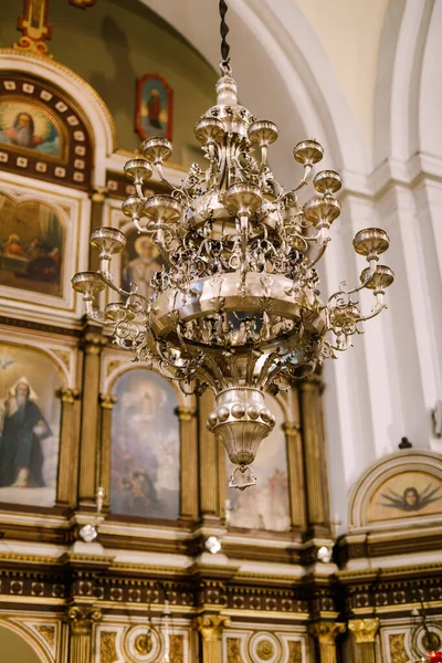 Gold chandelier hanging on a chain in the church against the background of the iconostasis — Photo