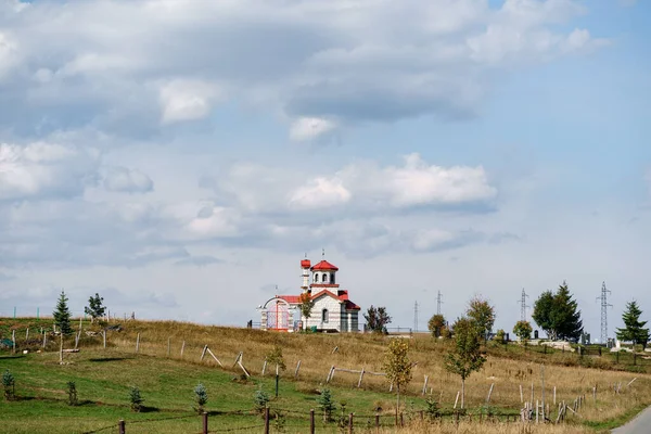 White brick church with red roof in the field — Foto de Stock