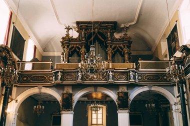 Antika bir organın önündeki kilisede bir zincirde avize.