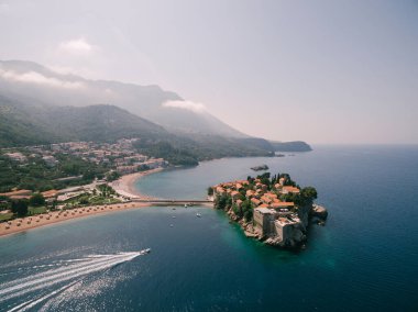 Sveti Stefan adasına giden yat köpüklü bir iz bırakır.