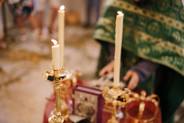 Kaarsen branden op kandelaars voor de priester in de kerk. — Stockfoto