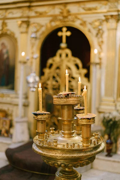 Panikandilo dorado con velas delante del altar con el iconostasio en la iglesia —  Fotos de Stock