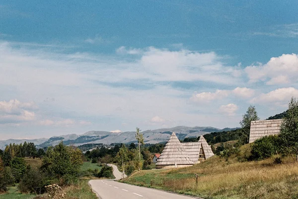Straße zum Dorf mit kegelförmigen und dreieckigen Häusern — Stockfoto