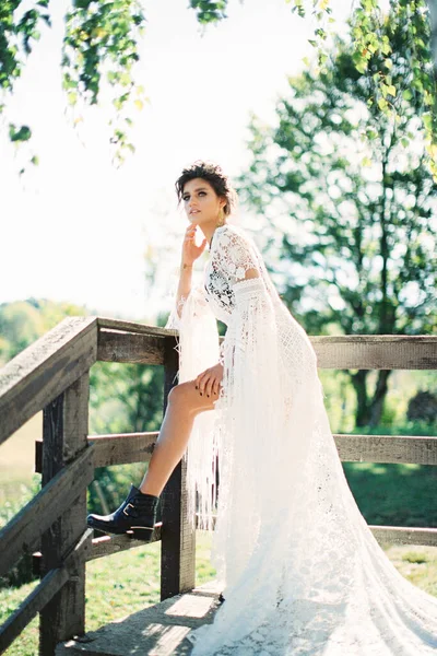 Gadis dalam gaun wicker putih berdiri bersandar di pagar kayu — Stok Foto
