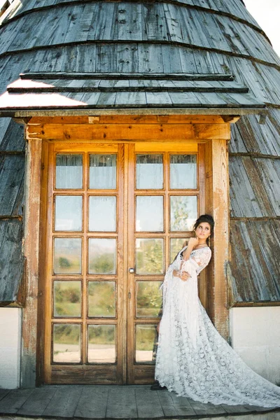 白いウィッカーのドレスの花嫁はコーンハウスのドア枠にもたれて — ストック写真