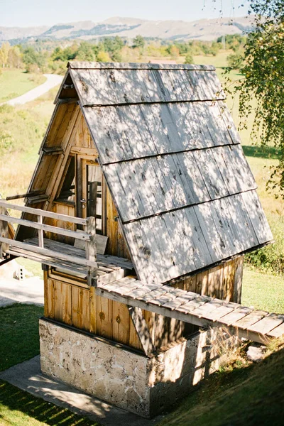 Casa triangular com uma varanda e uma ponte de madeira para a colina — Fotografia de Stock