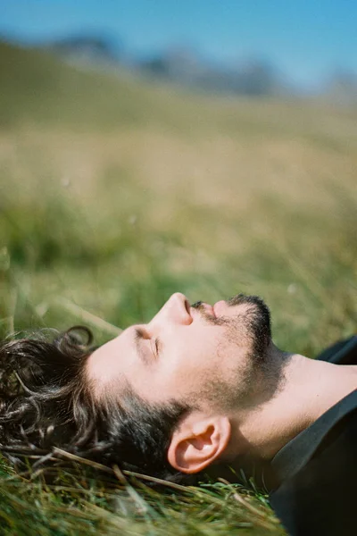 Profile of a man lying on green grass