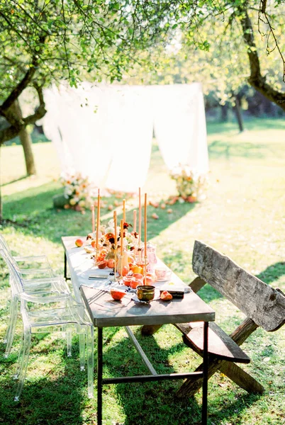Položený stůl se svíčkami v zelené zahradě — Stock fotografie