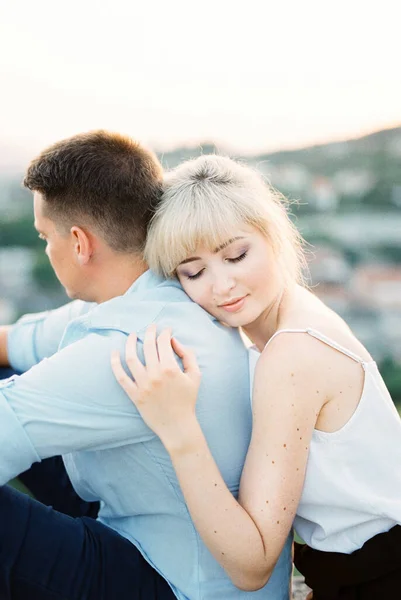 Una donna abbraccia un uomo da dietro con la testa sulla spalla. Ritratto — Foto Stock