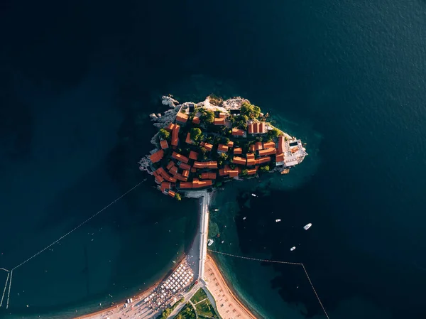 Ovanifrån av de röda taken av byggnader på ön Sveti Stefan och stranden — Stockfoto