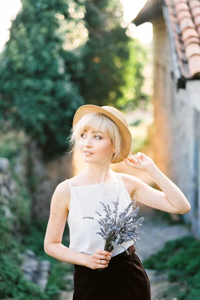 手にラベンダーの花束を持つわらの帽子の女性。肖像画 — ストック写真