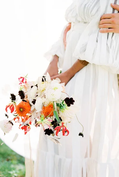 Muž objímající ženu s kyticí u bílých záclon — Stock fotografie