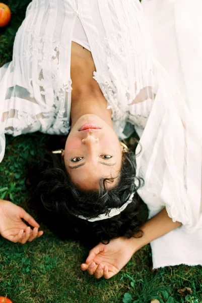 흰옷을 입은 여자가 푸른 잔디 위에 누워 있다. 위에서 본 풍경 — 스톡 사진