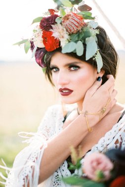 Çelenk takmış gelin saçını düzleştirir. Yakın plan.