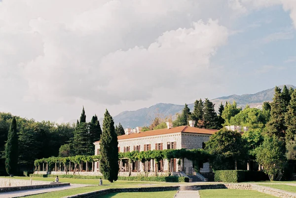 Villa Milocer in un giardino verde con montagne sullo sfondo. Montenegro — Foto Stock