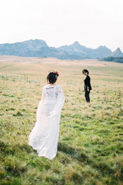 Groom attend que la mariée vienne le voir sur la pelouse verte. Vue arrière — Photo