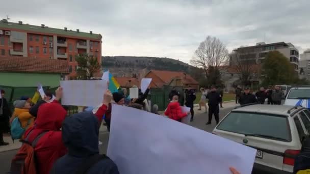 Podgorica, Montenegro - 06.03.22: Mensen met vlaggen en spandoeken op een anti-oorlogsbetoging. — Stockvideo