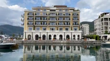 Hotel Regent against the backdrop of mountains near the water. Porto, Montenegro. High quality FullHD footage