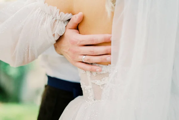 新郎的手放在新娘的背上 穿着白色蕾丝裙 高质量的照片 — 图库照片