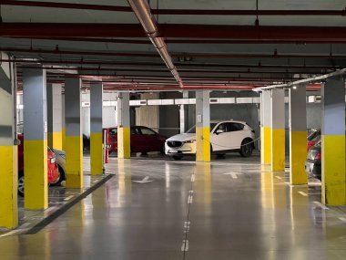 Otomobiller yeraltı otoparkında, sütunların arasındaki işaretli alanlarda. Yüksek kalite fotoğraf